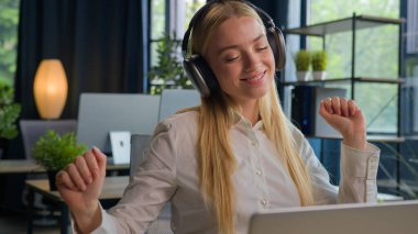 Kafkasyalı kadın işe ara veriyor rahat iş kadını gülümsüyor kulaklıkla müzik dinliyor kulaklıkla müzik dinliyor kulaklıkla kulaklıkla müzik dinliyor kulaklıkla kulaklıkla müzik dinliyor melodi dansı hareketinin tadını çıkarıyor