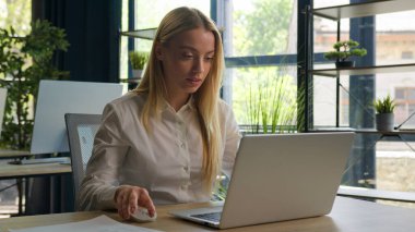 İş projesiyle uğraşan beyaz bir kadın ofisteki dizüstü bilgisayarında e-posta yazıyor mutlu bayan iş kadını yönetici internet bilgisayarlarında geziniyor neşeli kız gülümsemesi üzerine çalışıyor.