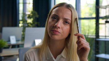 Düşünceli, düşünceli, yorgun, Kafkasyalı iş kadını, bayan işkadını, ofis çalışanı, genç bayan yönetici kalem işi fikri, zor bir soru, şüpheli görünen şüpheli bir sorunu çözmeyi düşünün.