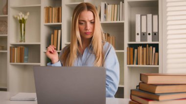 Kafkasyalı liseli kız öğrenci beyaz kız öğrenci hazırlık sınavına hazırlanıyor ev üniversite kütüphanesinde uzak öğrenim öğrenimi öğreniyor kitaplar yazıyor dizüstü bilgisayarla düşünceli bir şekilde not yazıyor.