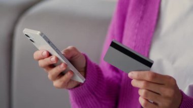 Kırpılmış manzara, kadın elleri tanınmaz hale getiriyor. Müşteri müşterisi kız alıcı cep telefonu ile ödeme satın alıyor. Kredi kartı numarası alışverişi yapıyor.