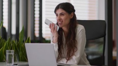 Gülümseyen iş kadını Kafkasyalı kız, hoparlör hoparlörü, cep telefonu, sesli mesaj, sesli mesaj, cep telefonu, mutlu iş kadını, ofisteki sesli mesajlar.