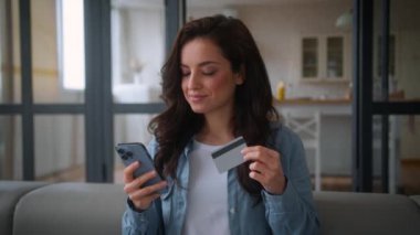 Gülümseyen Kafkasyalı kadın alıcı kız internet üzerinden alışveriş yapan cep telefonu bankası uygulaması internet mağazası akıllı telefonu kanepe koltuğunda kredi kartı ödemeleri için yemek siparişi veren