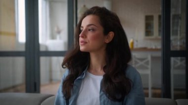 Çekici, mutlu, beyaz bir kadının portresi. Kendi dairesindeki sağlıklı, kaygısız kadın. Kameraya bakıp, kanepe ipoteği kredisinde dişlek gibi pozitif gülümseyen kadın.