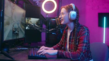 Mutlu jenerasyon z etkileyicisi blogger streamer genç bayan bayan bayan oyuncu kulaklıklar neon ışıklı bilgisayar oyunu bilgisayar oyunu bilgisayar oyunu siber spor yarışması online akış oyun bağımlısı klavye çalıyor