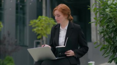 Kafkasyalı kadın iş kadını kadın sekreter bilgisayar kullanarak online video görüşmeleri yapan serbest çalışan açık hava şehirlerinde iş görüşmesi planlama görüşmeleri yazan notlar yazmayı tartışan.