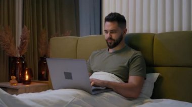 Kafkasyalı erkek yatağı uzaktan kumandalı bilgisayar yazıcısı ev bilgisayarı cihaz işadamı girişimci erkek serbest çalışan internet programcısı kullanıcı ağı teknolojisi yatak odası adamı