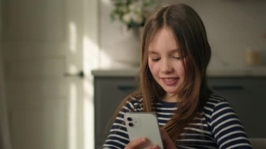 Küçük Kafkasyalı kız cep telefonu akıllı telefon internet Wi-Fi mesajlaşması mesajlaşması e-öğrenen küçük kız çocuk mesajları yazarak sanal web teknolojisi aygıtı