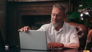 Yakın laptopta çalışan Kafkasyalı iş adamı erkek bilgisayar teknolojisi başarılı iş adamı patron kariyer kıdemli yönetici üst düzey yönetici yatırım finans şebekesi