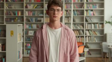 Kafkasyalı ergen çocuk, hoşnutsuz öğrenci, gözlüklü, erkek öğrenci, reddedilme jesti, reddedilme, okul akademisi üniversite kütüphanesinde kötü eğitim.