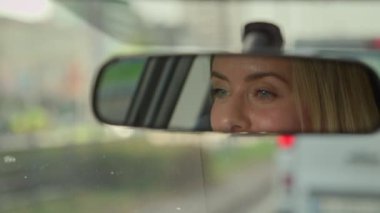 Ayna yansıması, şehirdeki kadın sürücünün beyaz kadın şoförü kadın otomobil sahibi iş kadını kız araba kullanıyor modern lüks elektrikli otomobil işe gidiyor seyahat trafik sigortası