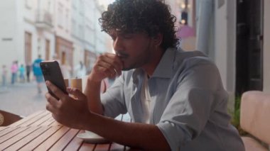 Üzgün, düşünceli, Hintli, Arap, erkek, iş adamı, kahve içen turist, mesaj okuyor, cep telefonu bağımlısı, kafası karışmış, sorunlu, açık hava telefonu kullanan, kafası karışmış,