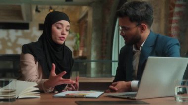 Çok ırklı iş ortakları erkek işkadını iş arkadaşları ofis sohbetleri müslüman akıl hocası kadın tesettür danışmanı Arap erkek müşteri evrak grafiklerini tartıştı