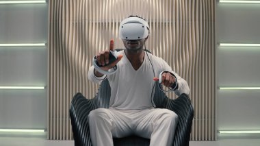 Gamer African American man male guy programmer in VR helmet virtual augmented reality glasses high-tech futurism cyber game online internet interface playing controllers design innovation metaverse clipart