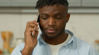 Kızgın sinirli Afrikalı etnik adam cep telefonuyla kötü konuşma yapıyor evde öfkeli adam akıllı telefon portresi bağırıyor, bağırıyor, sorun var diye bağırıyor.