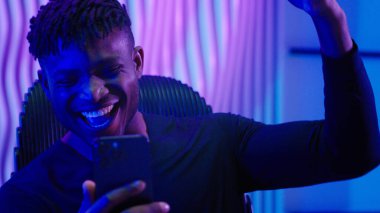 Afrikalı Amerikalı erkek, erkek, başarılı. Cep telefonu akıllı telefon uygulama şampiyonu. Başarılı bir galibiyet kazan.