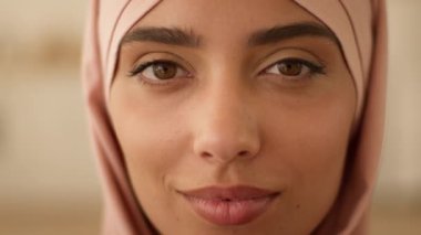 Son derece yakın bir portre gülümseyen güzel doğulu İslamcı kadın tesettürlü Müslüman kadın ev içinde Arap kadın mükemmel cilt İslam dini gülümsemesi dişlek sağlıklı dişler