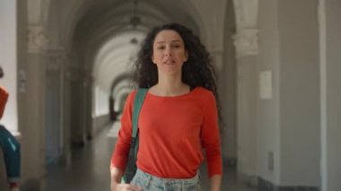 Latin kökenli kız öğrenci üniversite koridorunda yürüyor. Kafkasyalı iki kadın. Afrikalı Amerikalı kızlar omuz omuza yürüyorlar.