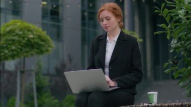 Düşünceli, kafası karışmış, genç, beyaz, kadın, iş kadını CEO 'su. Bilgisayarlı bilgisayar kullanarak iş planı üzerinde kafa yoruyor. Şehir merkezindeki açık ofis sorununu çözmeyi düşünüyor.