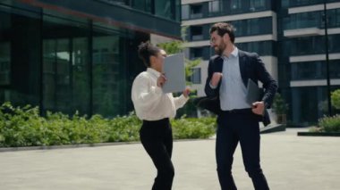 İki mutlu dans eden çok ırklı iş arkadaşı, Afrikalı Amerikalı kadın iş kadını, beyaz erkek iş adamı erkek dans, iyi iş başarısını kutluyor.