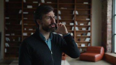 Gergin, ciddi, Kafkas, olgun, üst düzey erkek, yönetici, yönetici, patron. Somurtkan, cep telefonu cevap veren, akıllı telefonlardan konuşan, iş sorunları çözen, kapalı ofis içinde çözümü tartışan iş adamı.