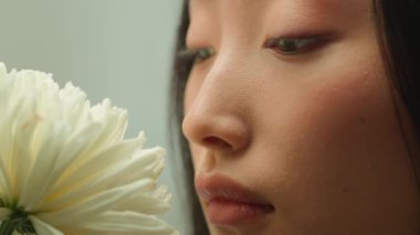 Güzel yüzlü Asyalı kadın Koreli Çinli kadın çiçek kokusu alıyor. Çiçek kokusu, çiçek kokusu doğal kozmetoloji cilt makyajı, kozmetik sağlık hizmetleri.
