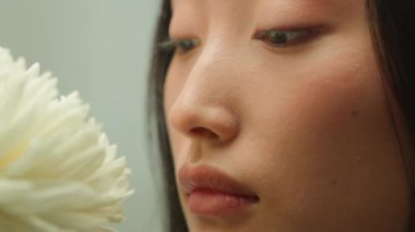 Kapalı yüzlü, Asyalı, sağlıklı, şehvetli, Koreli, Çinli, Japon kadın çiçek kokusu. Kokusunun tadını çıkar. Çiçek kokusu, çiçek kokusu, doğal kozmetik cilt bakımı, kozmetik güzellik.