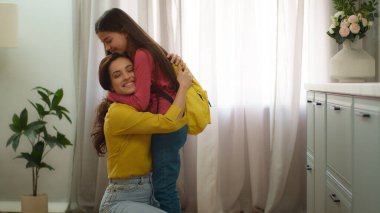 Mutlu aile, mutlu beyaz kadın, anne, baba, neşeli küçük kız, kız çocuk, kız kardeş, okul sonrası kardeş, kucaklaşma, sarılma, sarılma.