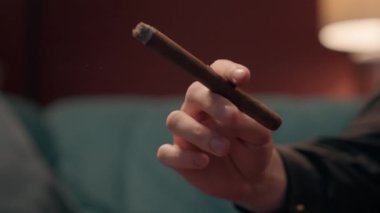 Kimliği belirsiz, başarılı, beyaz, tanınmayan zengin iş adamı, elinde puro tutan, uçlu sigara külü tüttüren bir adam. Sağlıksız yaşam tarzı kötü alışkanlık depresyon bağımlılığı