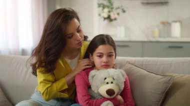 Endişeli Kafkasyalı ebeveyn kadın kendini suçlu hissediyor. Kadın anne özür diliyor. Küçük kızdan özür diliyor.