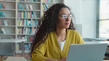 Latin Kafkasyalı İspanyol kadın öğrenci dizüstü bilgisayar teknolojisi siber uzay sanal proje diploması kütüphane kızı ödevi e-öğrenme kadın gözlüğü modern çalışma akıllı