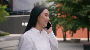 Mutlu Asyalı kadın gülen işveren müdürü şehir iş kadını konuşan cep telefonu akıllı kız iletişim anlaşması konuşması yapan kadın teknoloji şehri