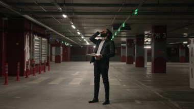 Sinirli, stresli, Arap bir adam, yeraltı otoparkında kötü haberler okuyan, bankacılık kredisi borçları, borç sorunu, işten çıkarma gibi sıkıntılar hisseden bir kağıt parçası okudu.