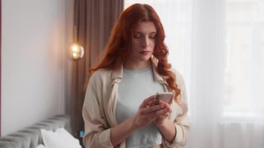 Düşünceli Kafkasyalı kadın cep telefonuyla yazışıyor internet uygulamasında mesajlaşıyor. Heyecanlı kız işaret parmağını kaldır. Aç ağzını. Evinde duygu sömürüsü yap.
