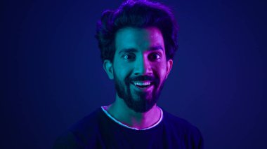 Profilde duran Hintli adam gülümseyen mutlu adama dönüyor gülümseyen mutlu adam geliştirici kodlayıcı bilgisayar teknolojisi korsanı Arap erkek neon ultraviyole yüksek teknoloji siber uzay