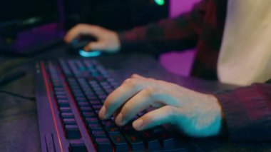 Mutlu Kafkasyalı oyuncu klavye bağımlısı, elinde fare tutan, elinde video oyunu oynayan adam, ev sahibi, olumlu oyuncu etkisinde gülümseyen, gülümseyen, siber spor akışı radyosu.