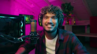 Hint Arap Müslüman erkek flamalı gülümseyen oyuncu siber spor siber uzay kulaklıkları takıyor mikrofon bağımlısı heyecanlı adam stüdyo kaydında yarışma teknolojisi ağı kuran internetteki erkek