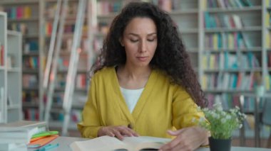 İspanyol Arap kadın kitap okuyor. Sayfa konsantrasyonu kız kütüphane öğrencisi. Üniversite sınavı hazırlık semineri.