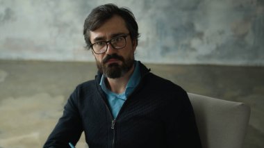 Dikkatli, ciddi, orta yaşlı, erkek psikolog, gözlüklü, psikoterapist, hastayı dinleyen, not yazan müşteriler. Pano danışmanlık hizmeti kabinesi