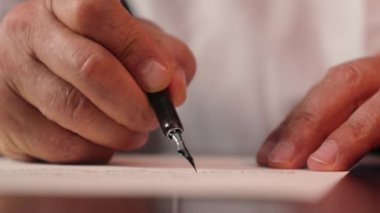 Fıskiye kalemi tutan yaşlı adamı kapat. Mektup yaz. Kağıt işi kaligrafi işadamı.