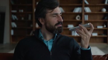 Başarılı bir Kafkasyalı, olgun iş adamı, erkek işadamı, cep telefonundan konuşan, akıllı teknolojiler kullanan akıllı telefonun içerideki hoparlörlerin sesli mesajlarını kaydetmesini emrettiğini söyleyen bir iş adamı.