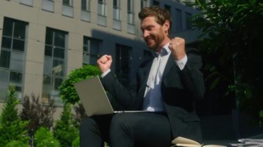 İş başarısı, zafer kazanmak kumarhane bahsi mutlu, gülümseyen, Kafkasyalı işadamı, orta yaşlı, erkek, dizüstü bilgisayarı kazanan, internette çalışan, açık havada çalışan, bilgisayar uzmanı.