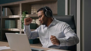 Ofis masasında bilgisayarlı mutlu bir işveren. Dinleniyor. Mola veriyor, Hint kökenli neşeli bir iş adamı.