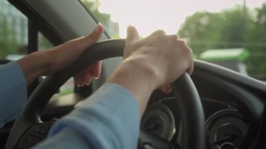 Tanımlanamayan eller direksiyona dokunuyor. Beyaz kadın şoför, araba içinde oturuyor. Kız, şehir test sürüşü güvenli taşımacılığında otomobil seyahati için hazır ol.