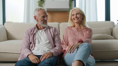 Mutlu Kafkasyalı sağlıklı aile evli karı koca ev sahibi kadın ev sahipleri kucaklaşır alınlarına dokunur ilişkiler kurar kameraya bakarak evde sigortanın keyfini çıkartırız.