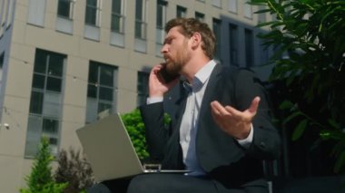 İş fiyaskosu çatışması Kafkasyalı kızgın işadamı orta yaşlı adam şehirde dizüstü bilgisayarda çalışan internet işçisi cep telefonu tartışması sorunu tartışması