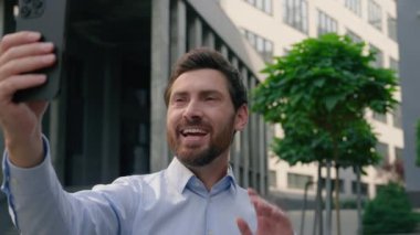 Smartphone sohbet video konferans uygulaması konuşan web kamerası beyaz iş adamı gülümseyen orta yaşlı adam iş adamı girişimci şehirdeki sanal sohbet cep telefonu çevrimiçi