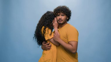 Çok ırklı, korkmuş, korkmuş bir çift Hintli erkeğin arkasına saklanan İspanyol kadını şoke etti. Şaşkınlık. Korkunç korku reaksiyonu.