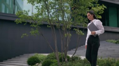 Asyalı Koreli bir kadın elinde klasör belgeleriyle geziyor iş kadını yönetici iş bulma merkezi avukatı başarılı yönetici işvereni şehir merkezindeki profesyonel kız şirketinin CEO 'su.