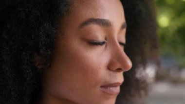 Yüzü Afro-Amerikalı bir kadın, sakin, genç bayan öğrenci, girişimci, işçi, iş kadını, etnik makyaj işçisi.